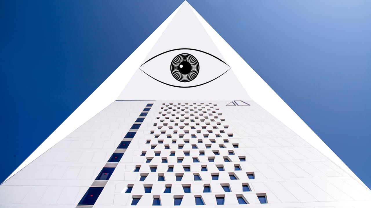 Modern building with geometric shapes and eye symbol under a clear blue sky.